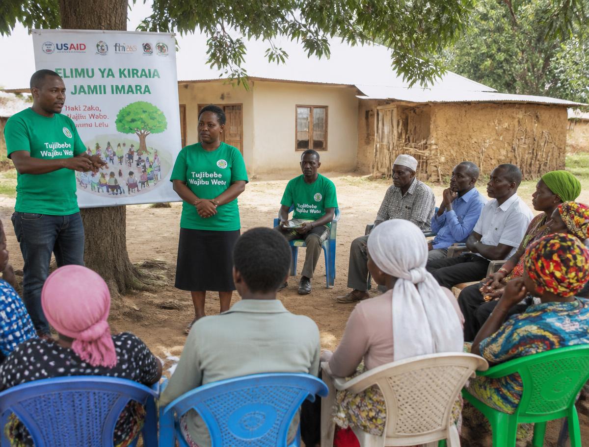 Volunteers in green shirts leading a civic education meeting in a Kenyan village